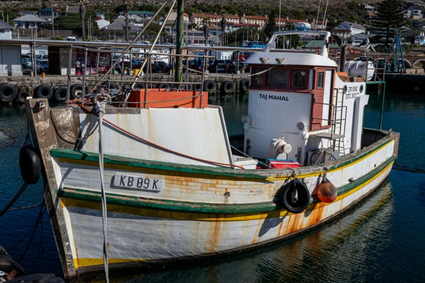 a boat docked in a harbor with other boats in the background ufU8ID