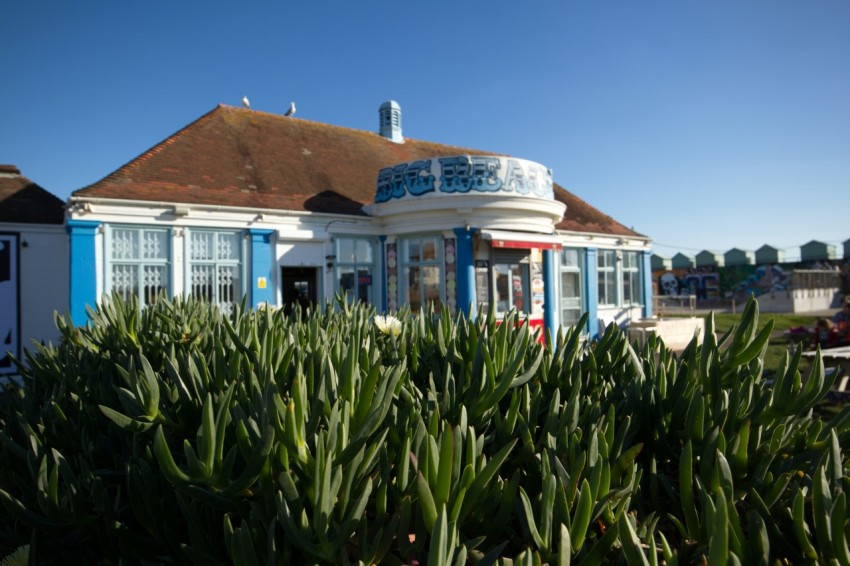 a blue and white building sitting next to a lush green field