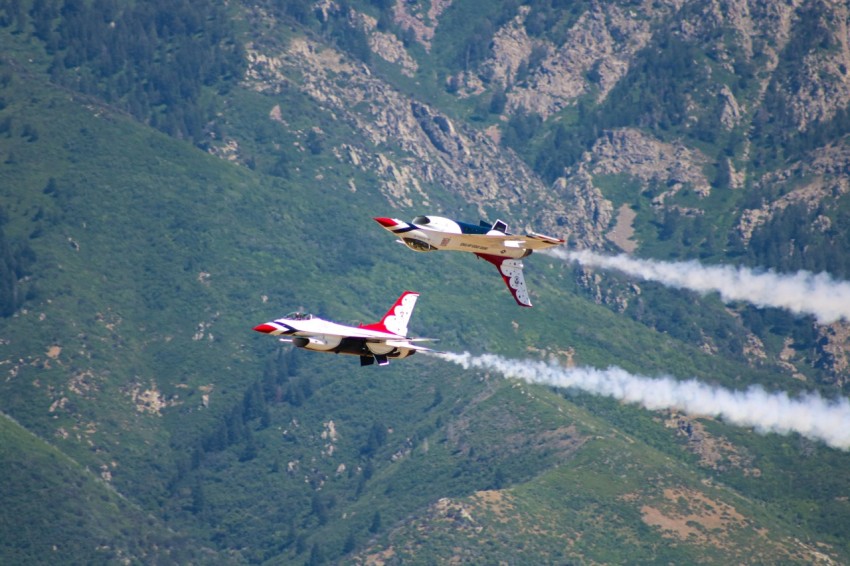 two planes flying in the air with smoke coming out of them
