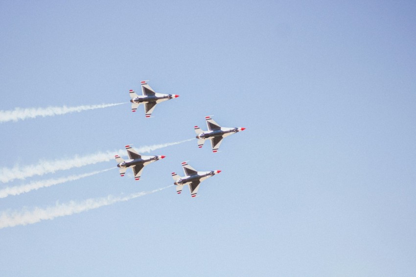 a group of jets flying through a blue sky