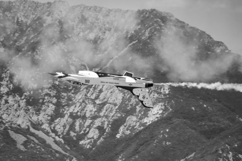 a small plane flying over a mountain range