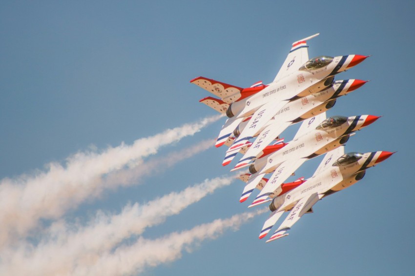 a group of fighter jets flying through a blue sky WS0Q