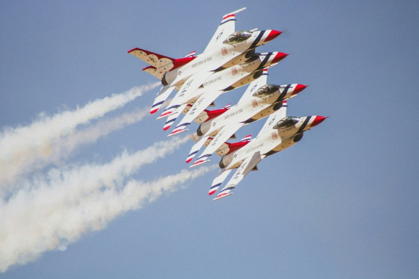 a group of fighter jets flying through a blue sky