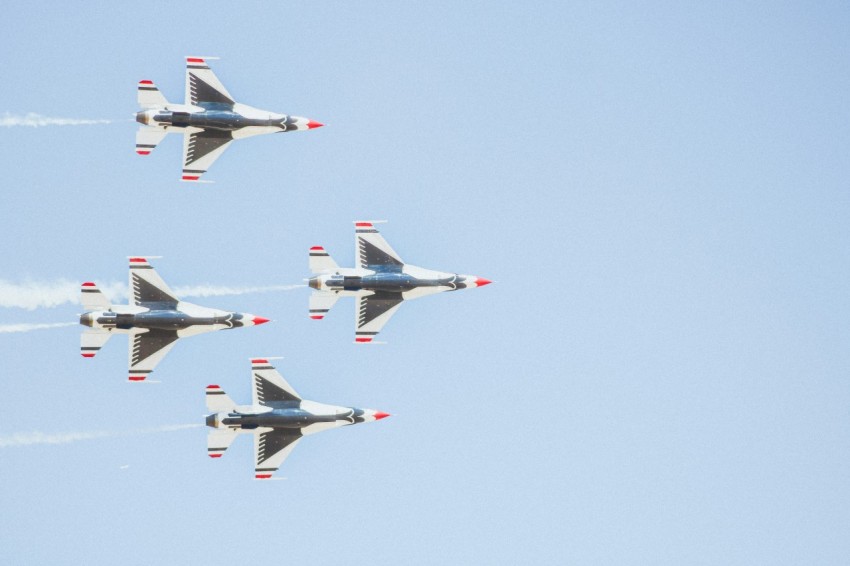 a group of fighter jets flying through a blue sky