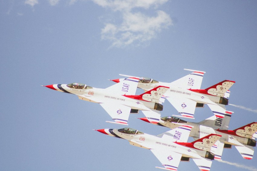 a group of fighter jets flying through a blue sky