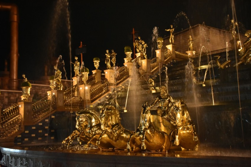 a group of golden statues sitting on top of a fountain