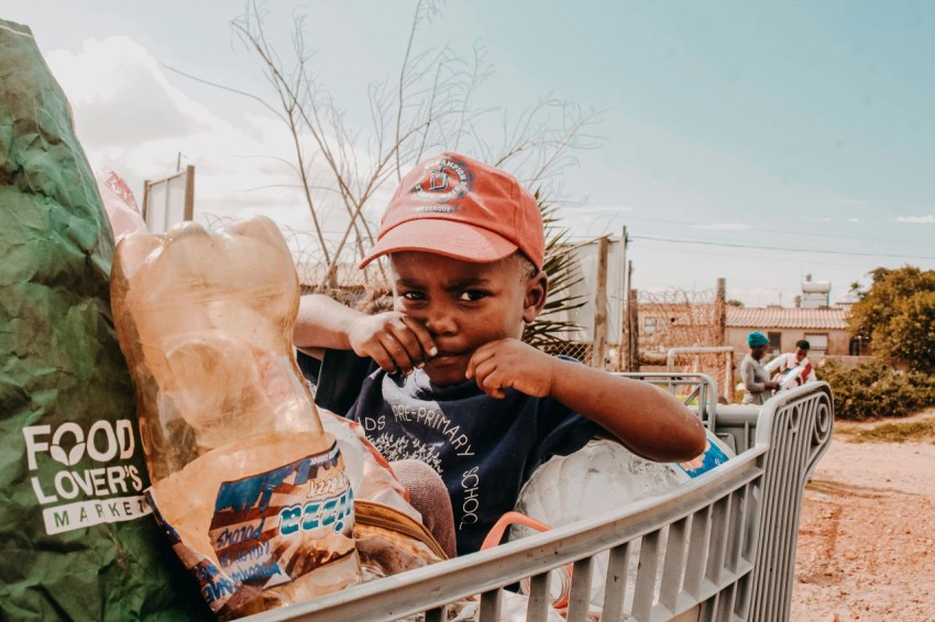 a young boy sitting in a shopping cart