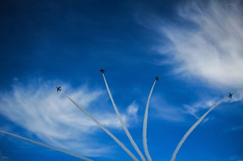 a group of airplanes flying through a blue sky R41CRDTxb