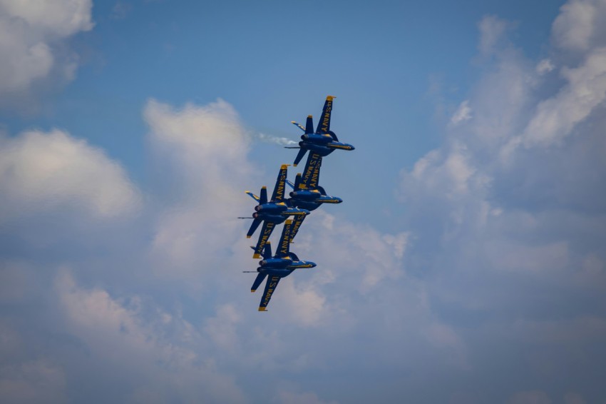 a group of fighter jets flying through a cloudy sky