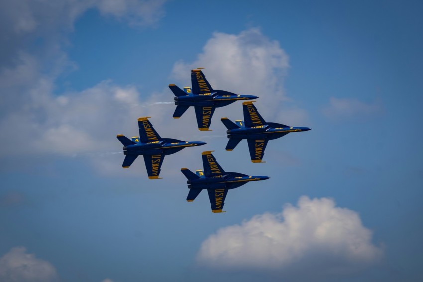 a group of fighter jets flying through a blue sky