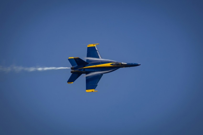 a fighter jet flying through a blue sky