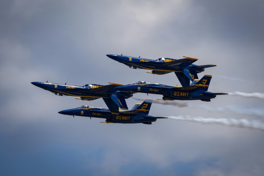 a group of fighter jets flying through a cloudy sky