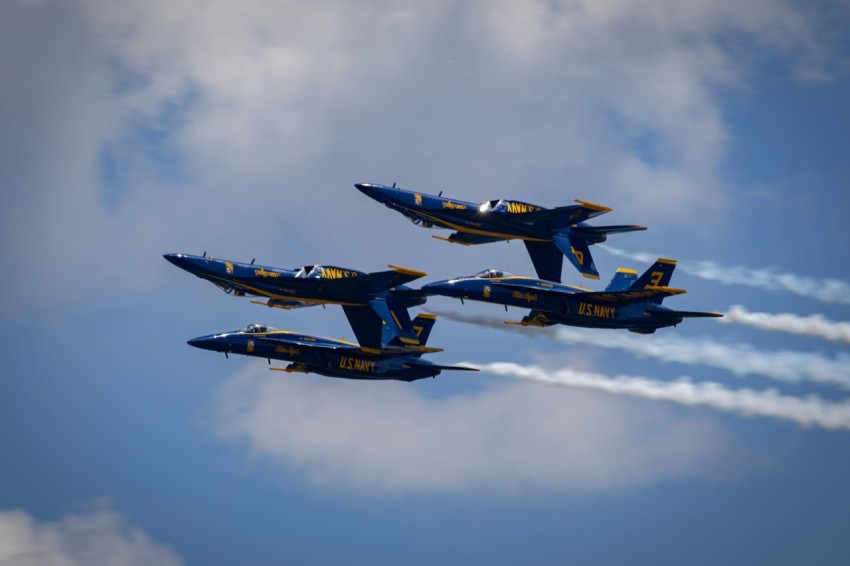 a group of fighter jets flying through a cloudy sky