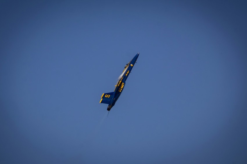 a small airplane flying through a blue sky