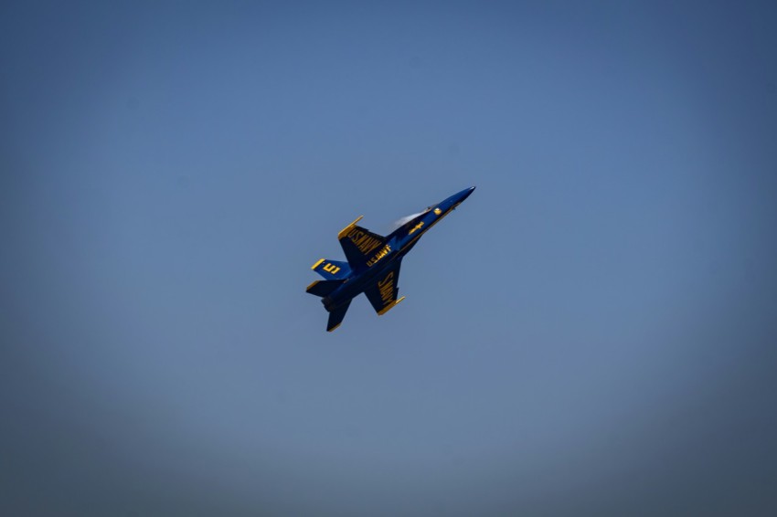 a fighter jet flying through a blue sky