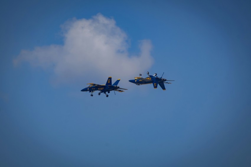 two fighter jets flying through a blue sky