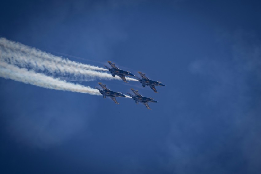 a group of jets flying through a blue sky