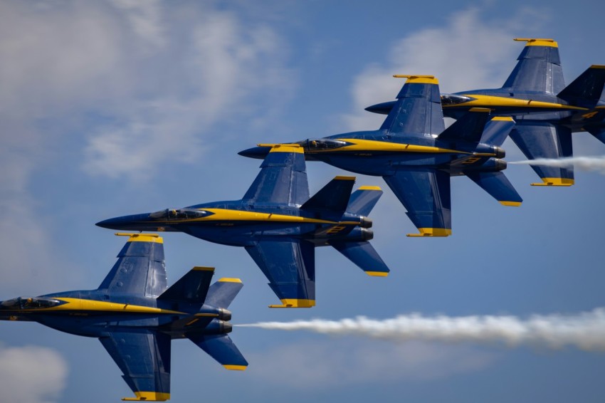 a group of fighter jets flying through a blue sky