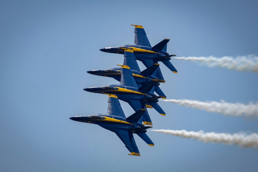 a group of fighter jets flying through a blue sky