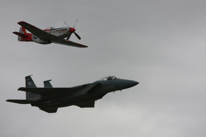 a couple of fighter jets flying through a cloudy sky