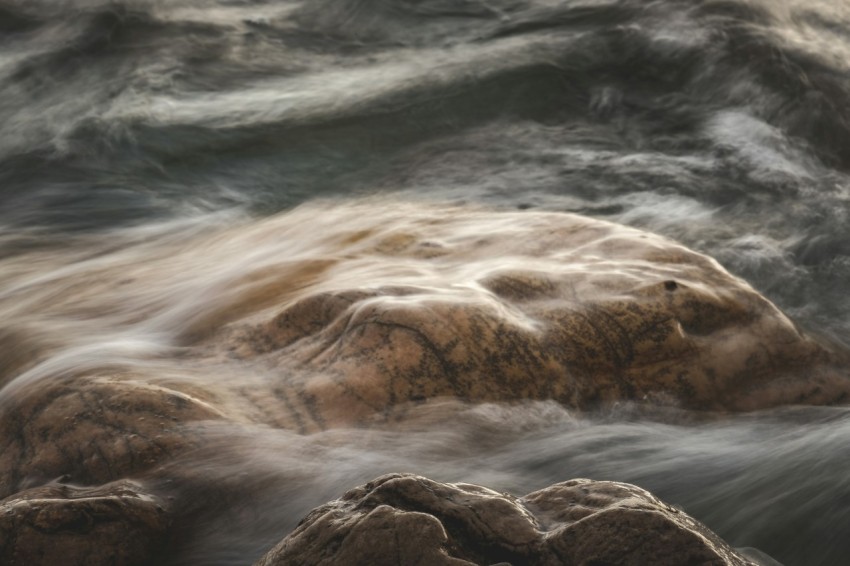 a close up of a rock in a body of water boB5