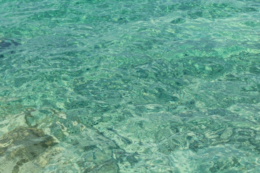 a man standing in the ocean with a surfboard H0zZr3f