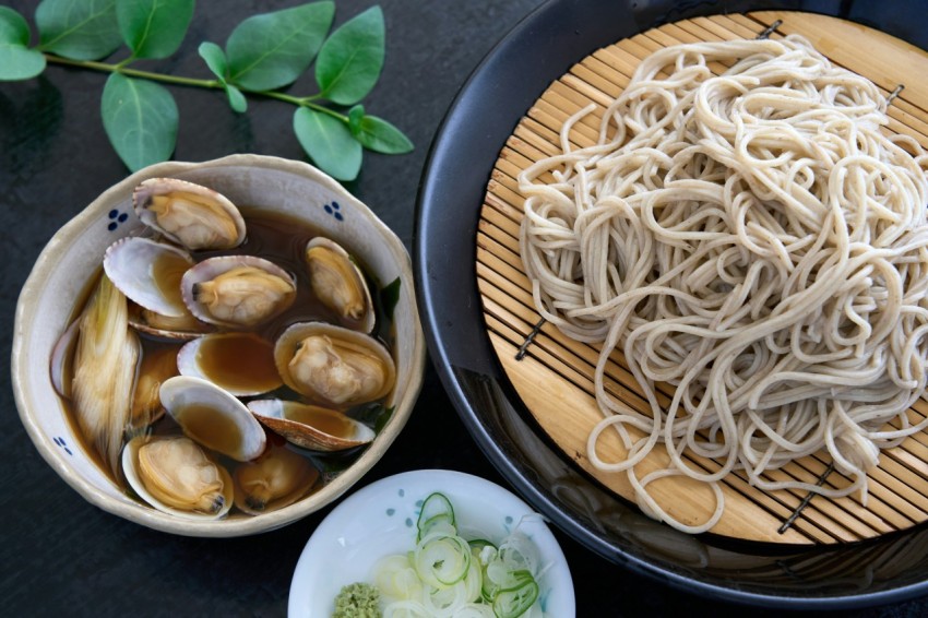 a plate of noodles and a bowl of clams