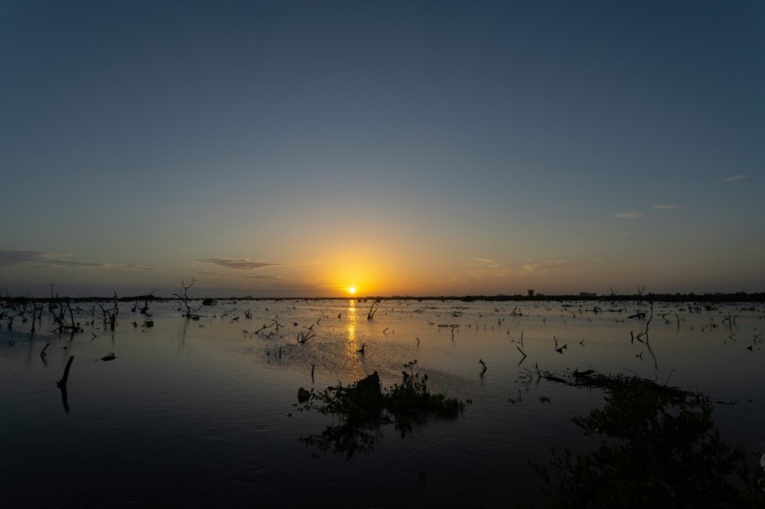 the sun is setting over a body of water