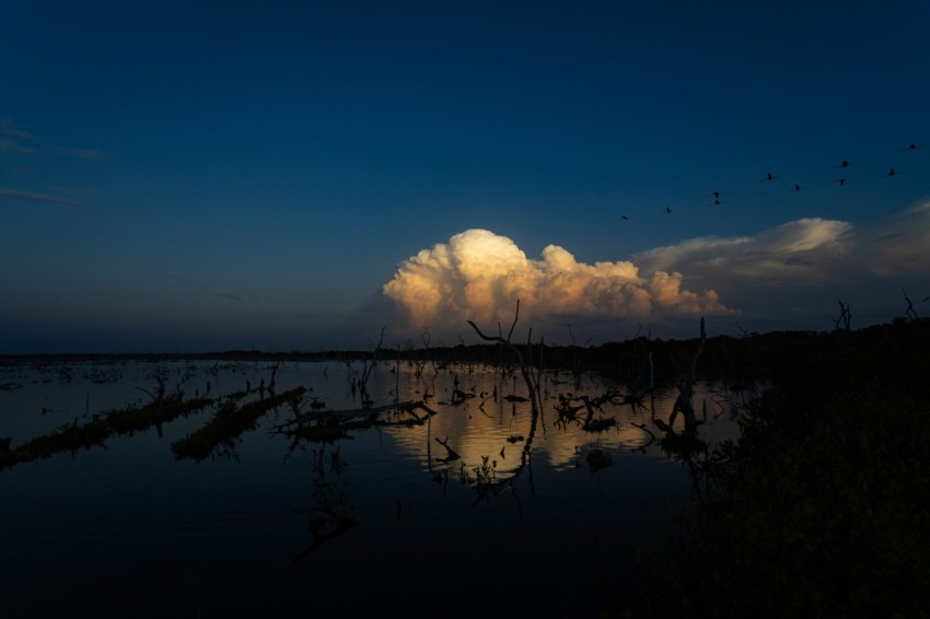 a large cloud is in the sky above a body of water