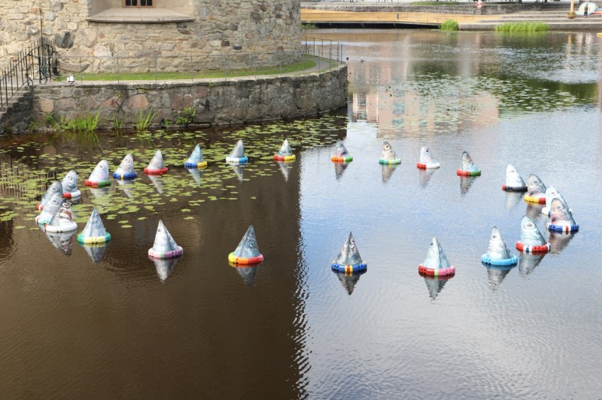 a group of paper boats floating on top of a lake