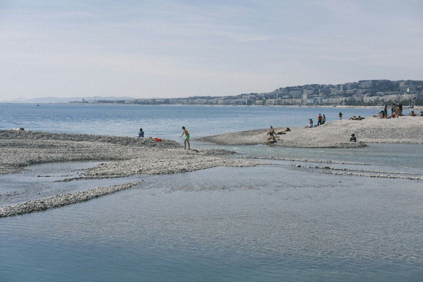 a group of people standing on top of a sandy beach