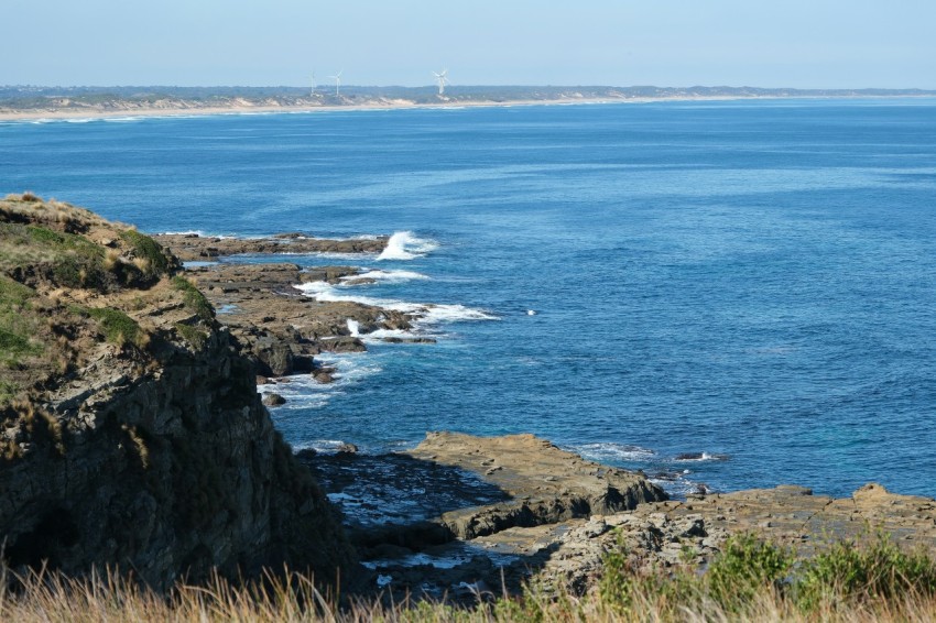 a large body of water sitting next to a lush green hillside