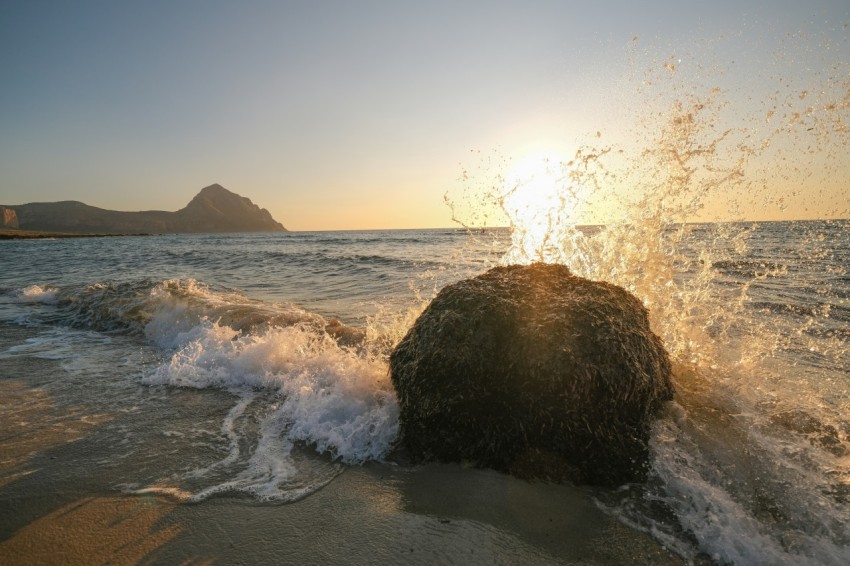 a large rock sitting on top of a sandy beach