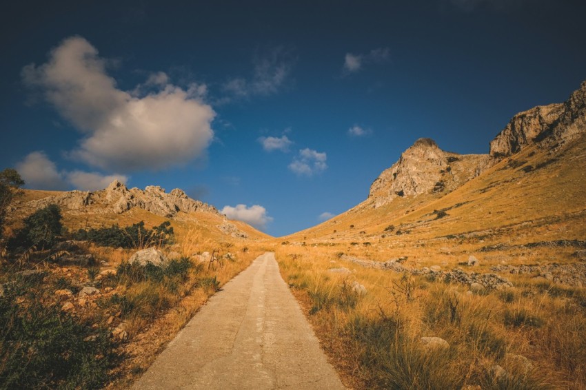 a dirt road in the middle of a mountain range IDOr