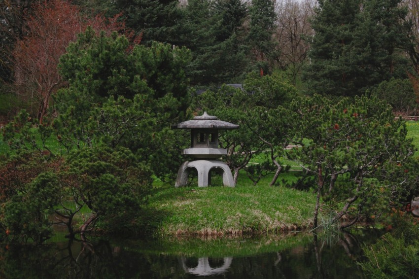 a small pond with a small pavilion in the middle of it