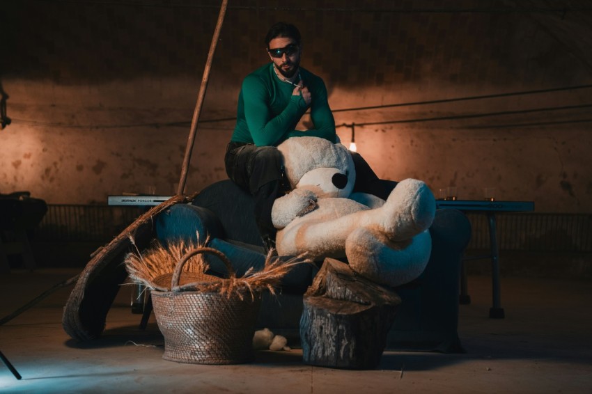 a man sitting on top of a pile of stuffed animals