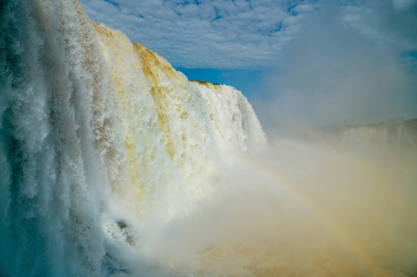 a large waterfall with a rainbow in the middle of it