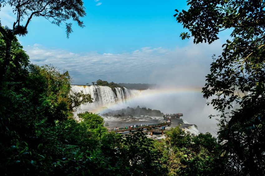 a rainbow in the sky over a waterfall