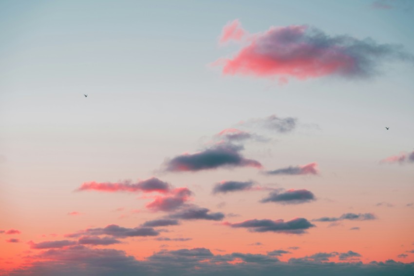 a plane flying in the sky at sunset