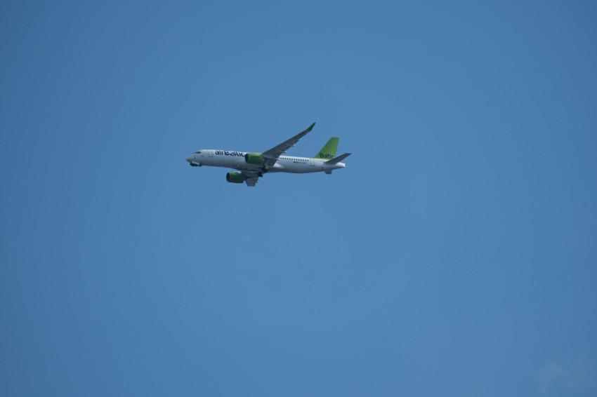 an airplane is flying in the blue sky