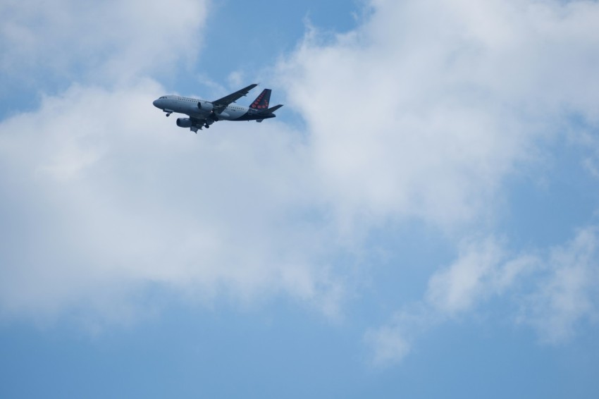 an airplane flying in the sky with a cloud in the background