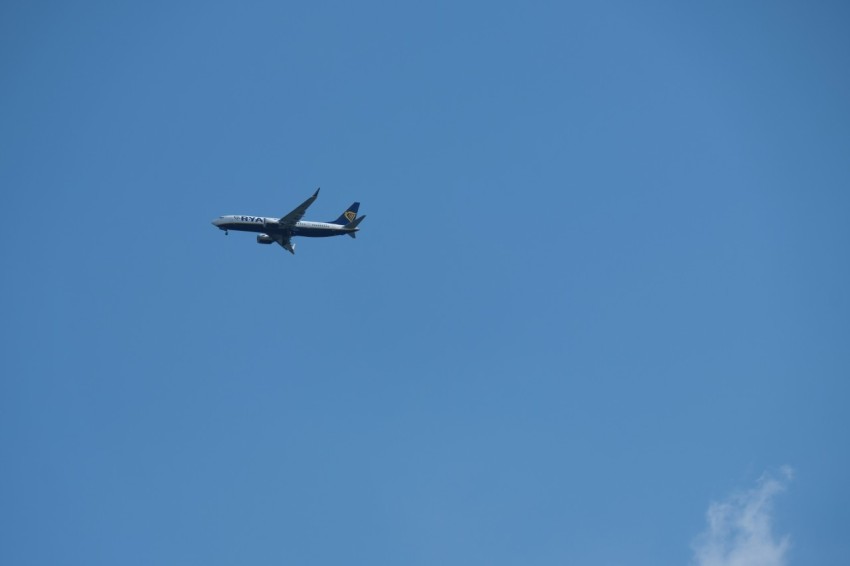 an airplane is flying in the blue sky