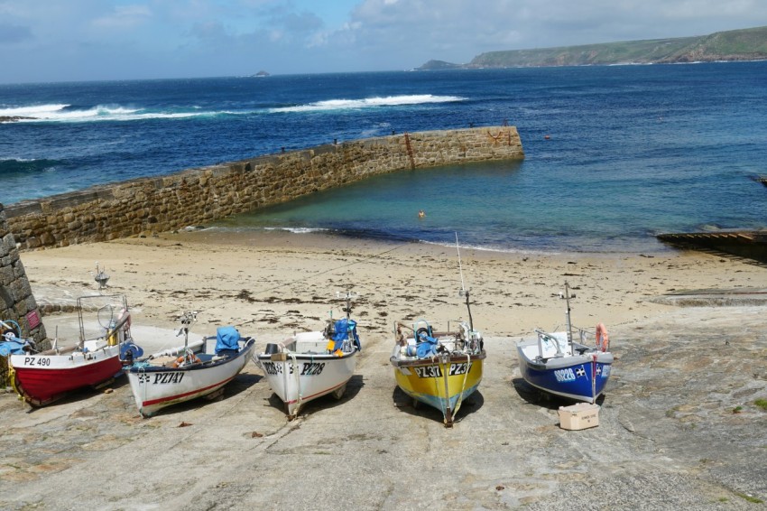 a group of boats sitting on top of a sandy beach