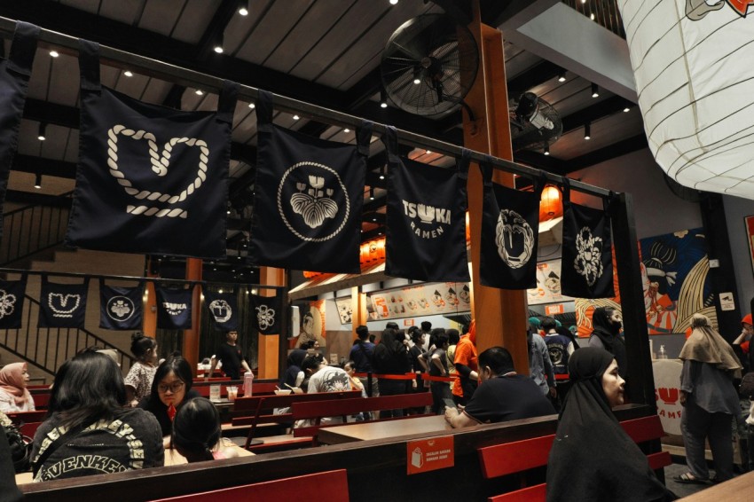 a group of people sitting at tables in a restaurant