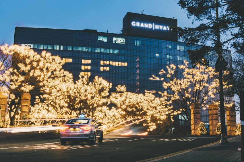 sedan running near grand hyay building during dusk