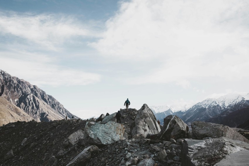 person standing on rocky mountain during daytime