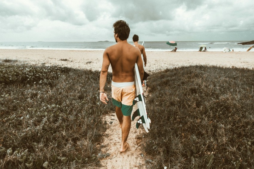 man carrying surfboard