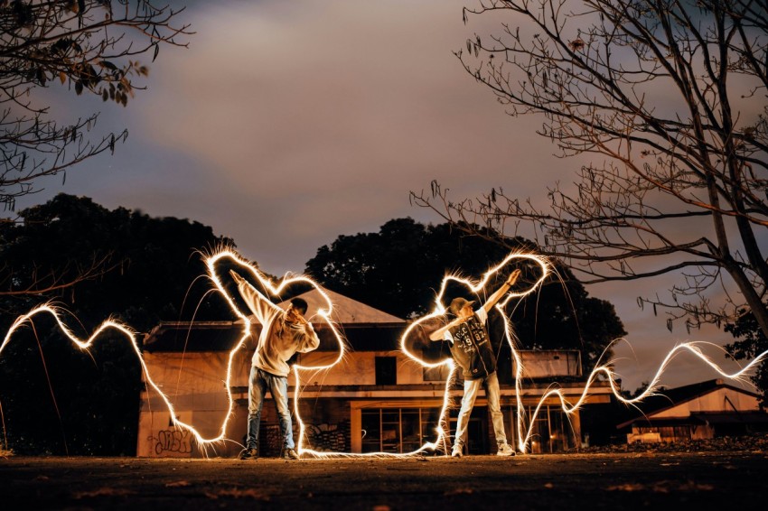 two men lifting one arm with led lights