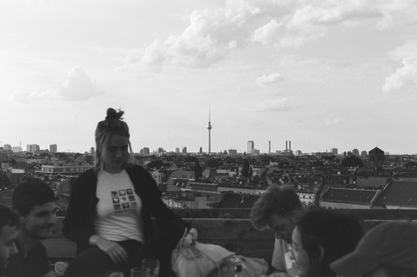 grayscale photo of man in black crew neck t shirt sitting on bench