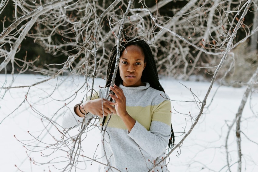 woman holding tree branch during winter